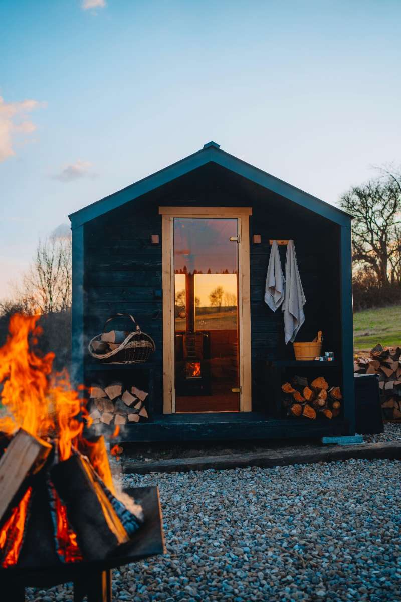 Exklusive Außensauna "Honey" aus Fichte, skandinavisches Design, Wellness-Atmosphäre, Tiny4You, gepflegte Holzoptik, im Gartenstehend
